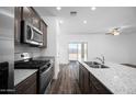 Close up of the kitchen, featuring stainless steel appliances, granite countertops and a kitchen island with a sink at 24593 W St Catherine Ave, Buckeye, AZ 85326