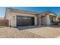 Single-story home with a two-car garage and stone accents at 9447 W Patrick Ln, Peoria, AZ 85383