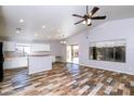 Spacious living room features a ceiling fan, wood-look flooring, and access to the backyard at 22264 N Kingston Dr, Maricopa, AZ 85138