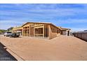 View of a new home construction, highlighting the wood framing and structural design under a blue sky on the property lot at 3329 W Desert Dawn Dr, Phoenix, AZ 85083