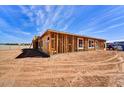 Construction progress of modern home with a framed window and newly installed stud walls under blue sky at 3330 W Desert Dawn Dr, Phoenix, AZ 85083