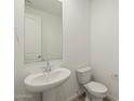 Well-lit half-bathroom with a pedestal sink and modern fixtures at 37014 W La Paz St, Maricopa, AZ 85138