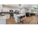 Charming kitchen boasts white cabinets, stainless steel appliances, a center island with bar stool seating, and wood floors at 1413 E Windsor Ave, Phoenix, AZ 85006