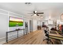 This living room features hard floors, a ceiling fan, a flat screen television, and is adjacent to the kitchen at 1413 E Windsor Ave, Phoenix, AZ 85006