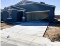 New home showing unfinished driveway and open garage with neutral color scheme against a sunny sky at 46963 W Coe St, Maricopa, AZ 85139