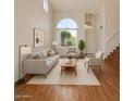 Bright living room with large window, modern furnishings, and hardwood floors at 1926 E Siesta Ln, Phoenix, AZ 85024