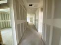 Bright hallway with fresh drywall, offering a glimpse of natural light at the far end at 46923 W Old Timer Rd, Maricopa, AZ 85139