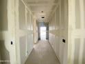 Hallway featuring smooth drywall, leading to a bright end with a future outdoor view at 46923 W Old Timer Rd, Maricopa, AZ 85139