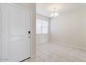 Bright entryway features neutral paint, tile flooring, and a modern chandelier in the adjacent room at 38120 W Excussare Way, Maricopa, AZ 85138