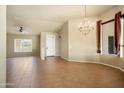 Spacious living room featuring a decorative chandelier, neutral walls and tiled floors, enhancing its appeal at 2606 N 159Th Dr, Goodyear, AZ 85395