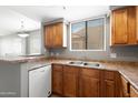 Kitchen showcasing wood cabinets, a stainless sink, and views into the adjacent dining and living areas at 4925 E Desert Cove Ave # 350, Scottsdale, AZ 85254