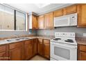 Well-lit kitchen with light wood cabinets, updated appliances, and a stainless steel double sink at 4925 E Desert Cove Ave # 350, Scottsdale, AZ 85254