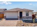Charming single-story home featuring a brick driveway, attached garage, and inviting entrance at 16923 W Siesta Way, Goodyear, AZ 85338