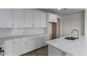 Bright, modern kitchen boasts white cabinets, subway tile backsplash, and stainless steel sink at 18605 E Panchito Dr, Gold Canyon, AZ 85118