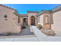 Inviting home facade featuring a well-maintained exterior, arched entrance, and professionally landscaped front yard at 32030 N 20Th Ln, Phoenix, AZ 85085