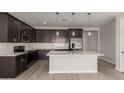Contemporary kitchen showcases stainless steel appliances, white countertops, island and dark cabinets at 18714 E Panchito Dr, Gold Canyon, AZ 85118