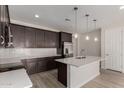 Well-lit kitchen boasts dark wood cabinets, stainless appliances, island and subway tile backsplash at 18714 E Panchito Dr, Gold Canyon, AZ 85118