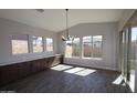 Sun-filled dining area with a modern chandelier and views of the backyard at 1021 W Ridge Rd, Apache Junction, AZ 85120