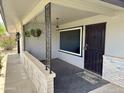 Welcoming covered front porch with decorative metal accents and neutral tones at 11133 W Cameo Dr, Sun City, AZ 85351