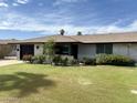 Inviting single-story home with lush green lawn and manicured front yard landscaping at 11133 W Cameo Dr, Sun City, AZ 85351