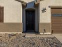 Front entrance with dark brown door and exterior light fixture at 37034 W La Paz St, Maricopa, AZ 85138