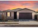 Charming single-story home with a two-car garage, stone accents, and low-maintenance landscaping at 16035 W Desert Hollow Dr, Surprise, AZ 85387