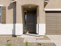 Welcoming front door framed by an arched entryway and decorative stone accents at 16082 W Desert Spoon Dr, Surprise, AZ 85387