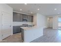 Modern kitchen with gray cabinets, white quartz countertops, and stainless steel appliances at 40000 W Bunker Dr, Maricopa, AZ 85138