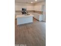 Modern kitchen featuring white cabinets, a large island, and tile floors at 15595 S 181St Dr, Goodyear, AZ 85338