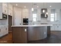 Kitchen island featuring a white countertop, wood-look base, and modern lighting fixtures at 1284 E Coconino Way, Gilbert, AZ 85298