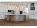 Close up of large kitchen island with a white countertop, wood-look base, and modern lighting fixtures at 1284 E Coconino Way, Gilbert, AZ 85298