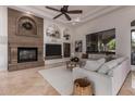 Comfortable living room with stone fireplace, coffered ceilings, a ceiling fan, and oversized windows at 2494 E Cloud Dr, Chandler, AZ 85249