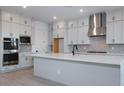 Modern kitchen with stainless steel hood, island sink, and gray cabinetry at 1300 E Penedes Dr, Gilbert, AZ 85298