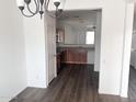 Open kitchen with wood cabinets, stainless appliances, and modern gray wood flooring at 11560 W Kinderman Dr, Avondale, AZ 85323