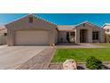 Charming single-story home featuring a well-manicured lawn and tile roof at 22364 N 67Th Dr, Glendale, AZ 85310