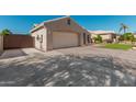 Side view of the home showing a long driveway and garage at 22364 N 67Th Dr, Glendale, AZ 85310
