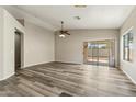 Open living area featuring modern gray vinyl flooring, neutral walls, ceiling fan and sliding glass doors to backyard at 6658 E San Cristobal Way, Gold Canyon, AZ 85118