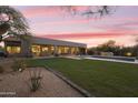 Expansive backyard featuring a pool, green lawn, and covered patio with outdoor seating at 7928 E Parkview Ln, Scottsdale, AZ 85255