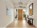 Bright foyer with wood flooring, a modern light fixture, and views to the outside at 7928 E Parkview Ln, Scottsdale, AZ 85255