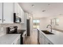 Modern kitchen with white cabinetry, stainless steel appliances, a large island, and stylish backsplash at 18197 W Cielo Grande Ave, Surprise, AZ 85387