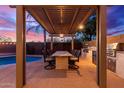 Enjoy outdoor dining under a pergola with a built-in kitchen at 21950 N 100Th Ave, Peoria, AZ 85383