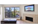 Bright living space with fireplace, and a large window overlooking a serene exterior view at 5122 N 31St Way # 244, Phoenix, AZ 85016