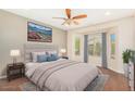 This cozy bedroom features a scenic view of the outdoors, a plush bed, and modern decor with hardwood flooring at 27182 W Potter Dr, Buckeye, AZ 85396