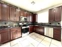 Spacious kitchen featuring dark wood cabinets and stainless steel appliances at 17323 W Woodlands Ave, Goodyear, AZ 85338