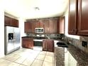 Modern kitchen with granite countertops and stainless steel appliances at 17323 W Woodlands Ave, Goodyear, AZ 85338