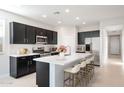 Modern kitchen boasts stainless steel appliances, quartz countertops, and a large center island with barstool seating at 4107 E Ghost Flower Ln, San Tan Valley, AZ 85140