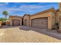 Three-car garage featuring dark doors and desert landscaping at 4301 E Taurus Pl, Chandler, AZ 85249