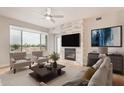 Bright living room with fireplace, ceiling fan, two chairs, and large window with view at 4803 N Woodmere Fairway -- # 2006, Scottsdale, AZ 85251