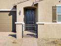 Dark brown front door with black gate and light fixtures at 17738 W Coolidge St, Goodyear, AZ 85395