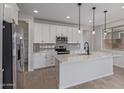 This kitchen showcases stainless appliances, quartz counters, white cabinets, and pendant lighting over an island at 18711 E Panchito Dr, Gold Canyon, AZ 85118